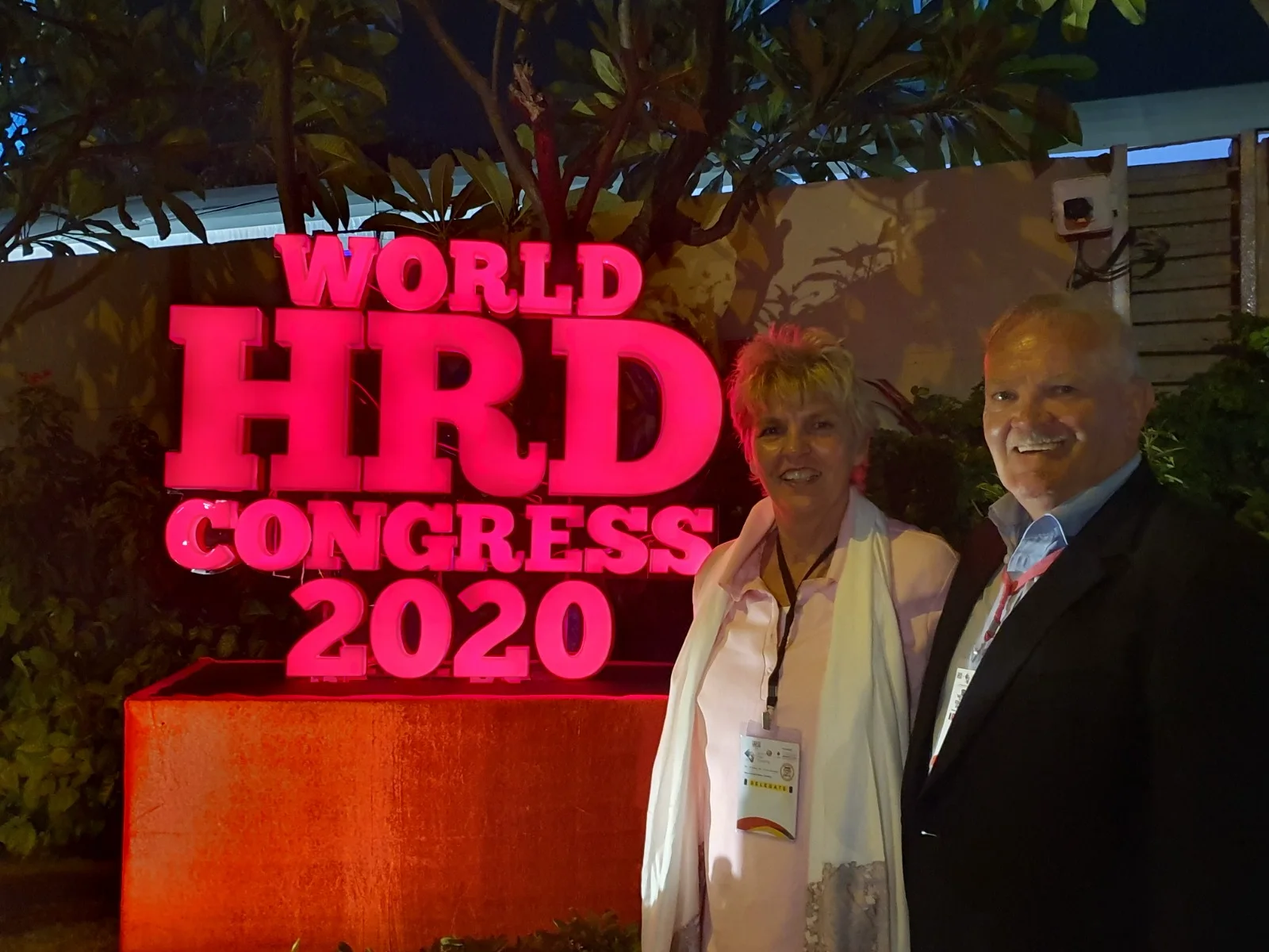 Bertie le Roux standing with his wife beside the World HRD Congress 2020 sign